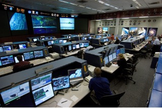 "Photo of mission-control operators used as an analogy for control logic that directs datapath actions."